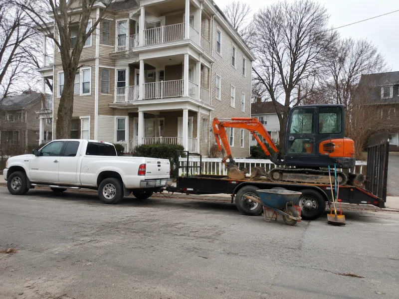 New Bedford Oil Tank Removal truck and mini excavator parked outside a South Coast home